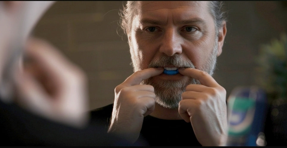 Man bijt in anti snurk prothese van Snorple